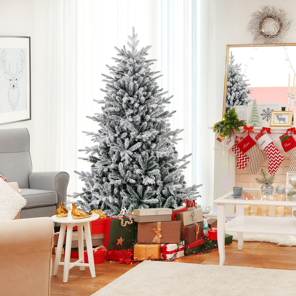 Flocked 6-foot Christmas tree with 8 lighting modes and multi-color LED lights, surrounded by festive gifts in a cozy.