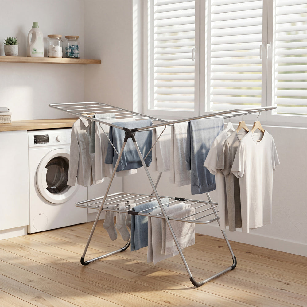 Foldable 2-tier clothes drying rack in a laundry room, featuring a sturdy aluminum and stainless steel design for.