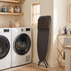 Space-saving foldable ironing board with a stable cross-shaped frame and padded heat-resistant surface for laundry rooms.
