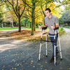 Folding height adjustable walking frame with armrest support, designed for stability and ease of movement outdoors.
