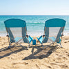 Two blue folding beach chairs with padded armrests and mesh fabric, perfect for relaxing by the ocean.