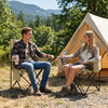 Two people relax in green folding camping chairs with mesh backrests, perfect for outdoor adventures and comfort.