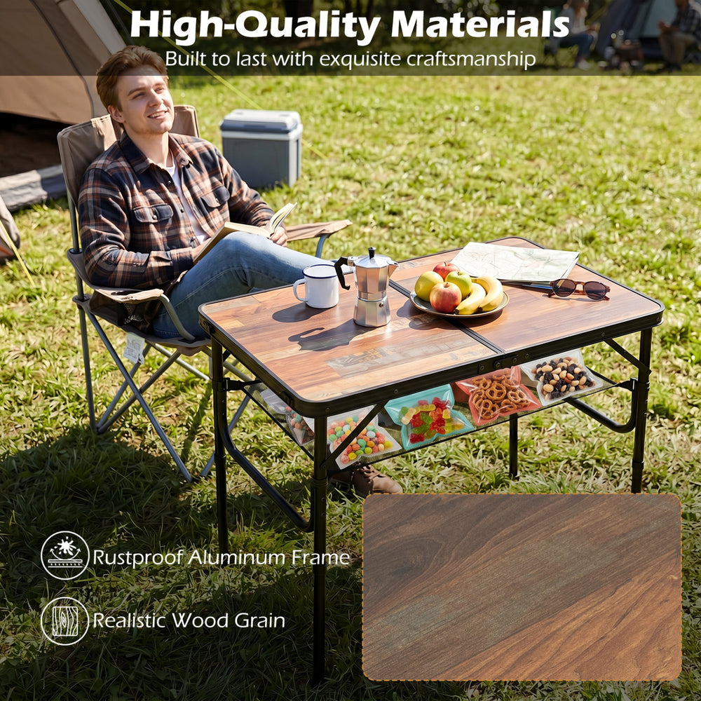 Folding camping table with adjustable heights, black and brown wood grain finish, ideal for outdoor use and storage.