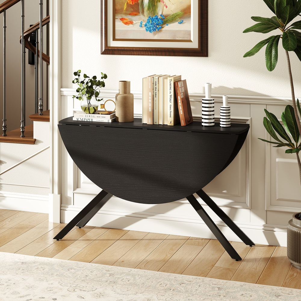Folding dining table with drop leaves in black, featuring an X-shaped metal frame, ideal for compact spaces.