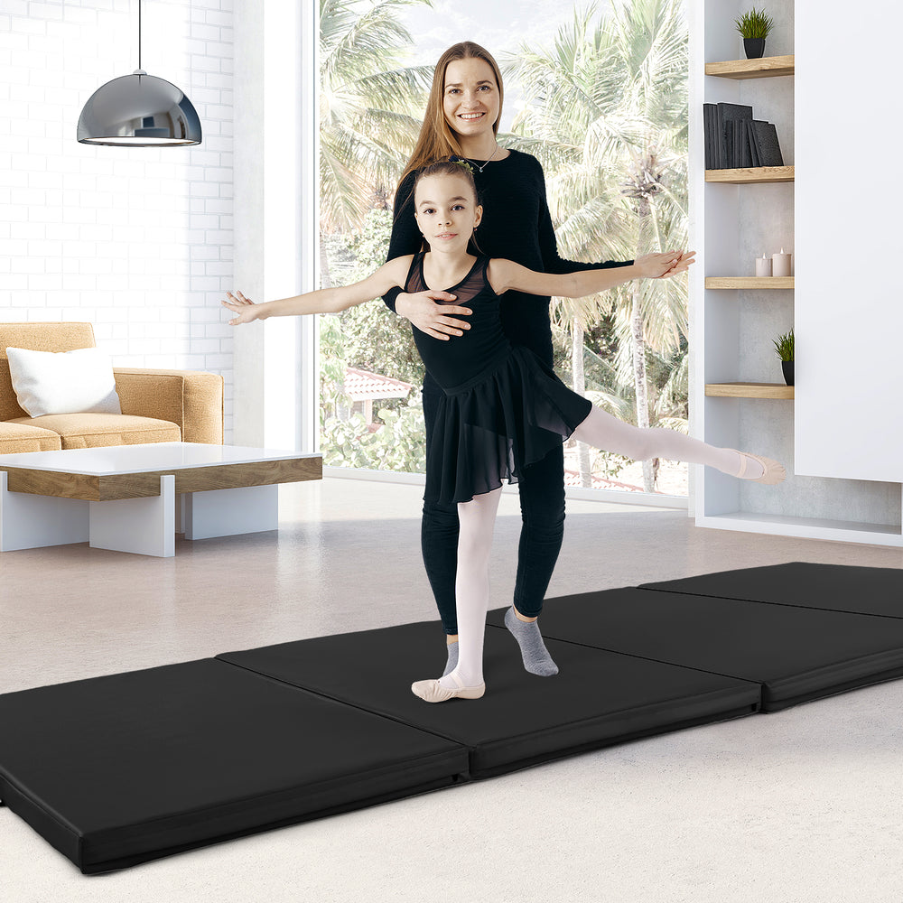 Black 4-panel folding exercise mat with carrying handles, ideal for gymnastics and stretching, shown in a home setting.