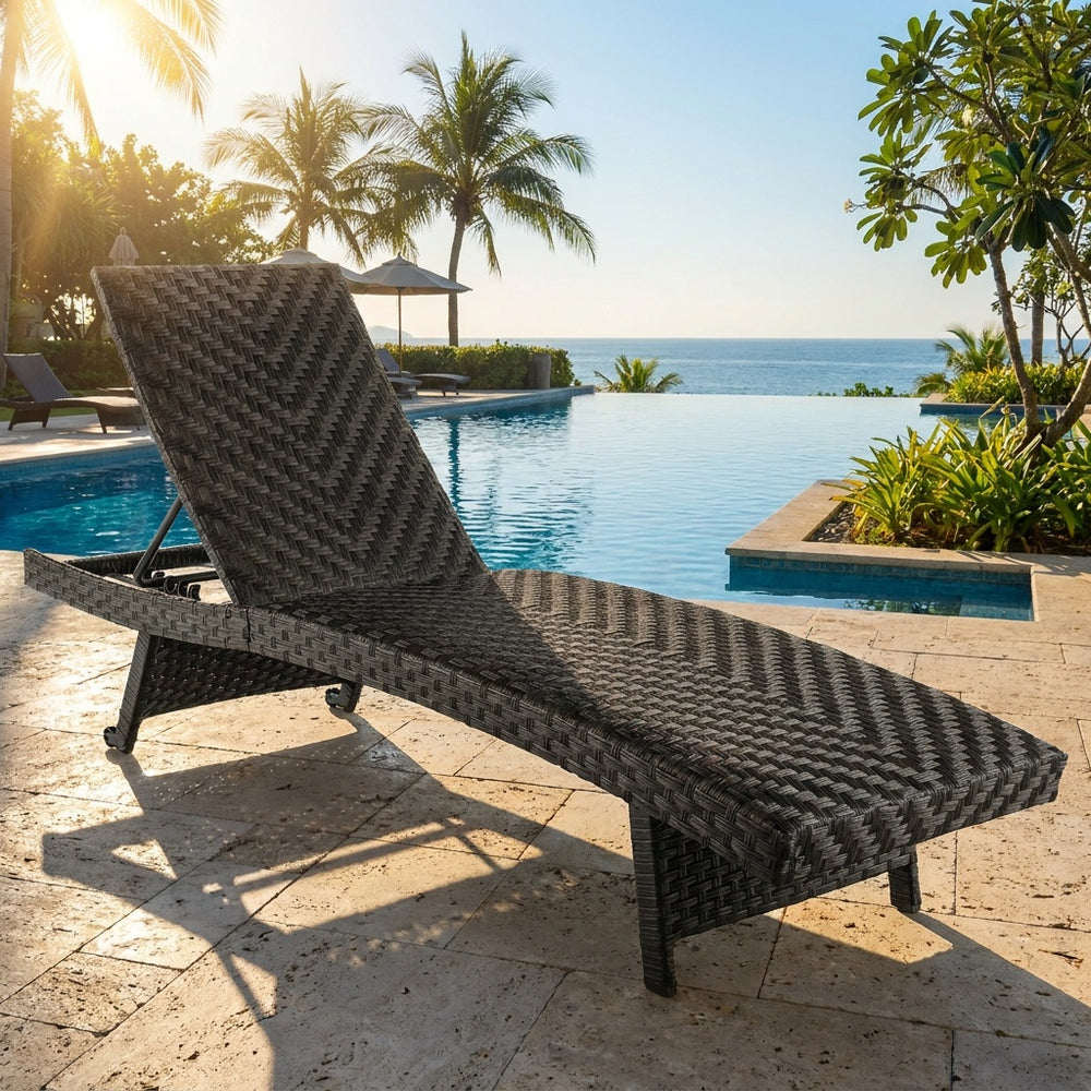 Folding padded rattan patio chaise lounge with adjustable backrest, perfect for poolside relaxation and durability.