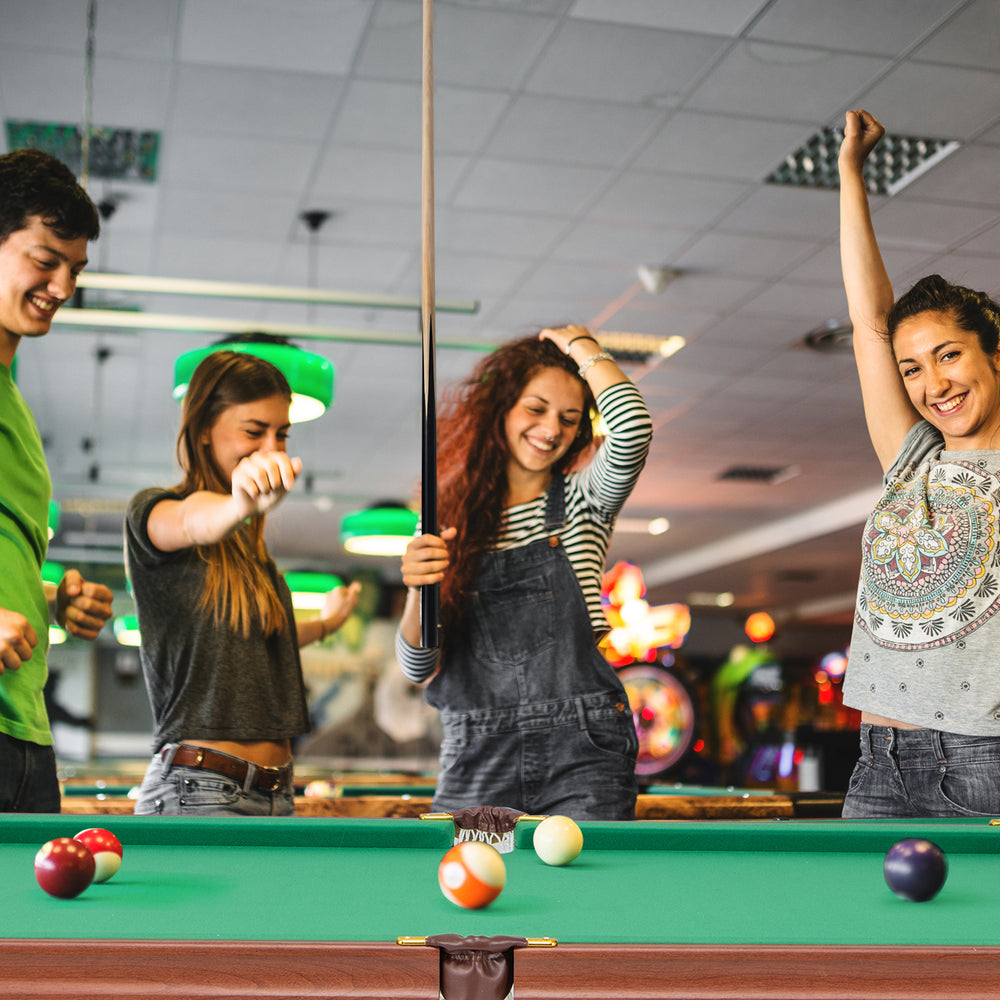 Folding portable billiards table game set with adjustable foot levelers, featuring players enjoying a game.