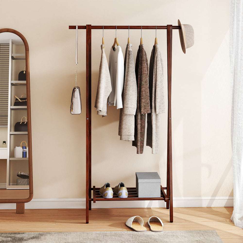 Folding rubber wood clothes hanging rack in walnut with bottom storage shelf for coats, hats, and shoes.