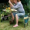 Folding garden kneeler pad and cushion seat, providing comfort while gardening, shown in use with flowers and tools.