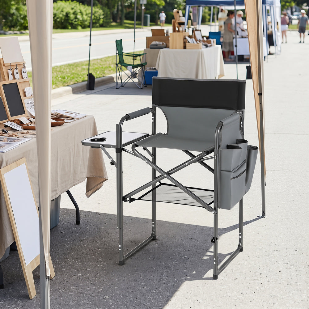 Folding tall director chair in gray features a 26-inch seat height, side table, and storage pockets for camping convenience.