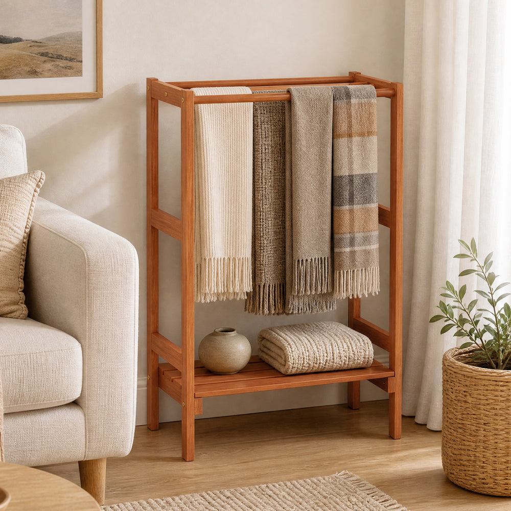 Freestanding towel rack in solid wood with three hanging bars and a bottom shelf for versatile storage in any room.