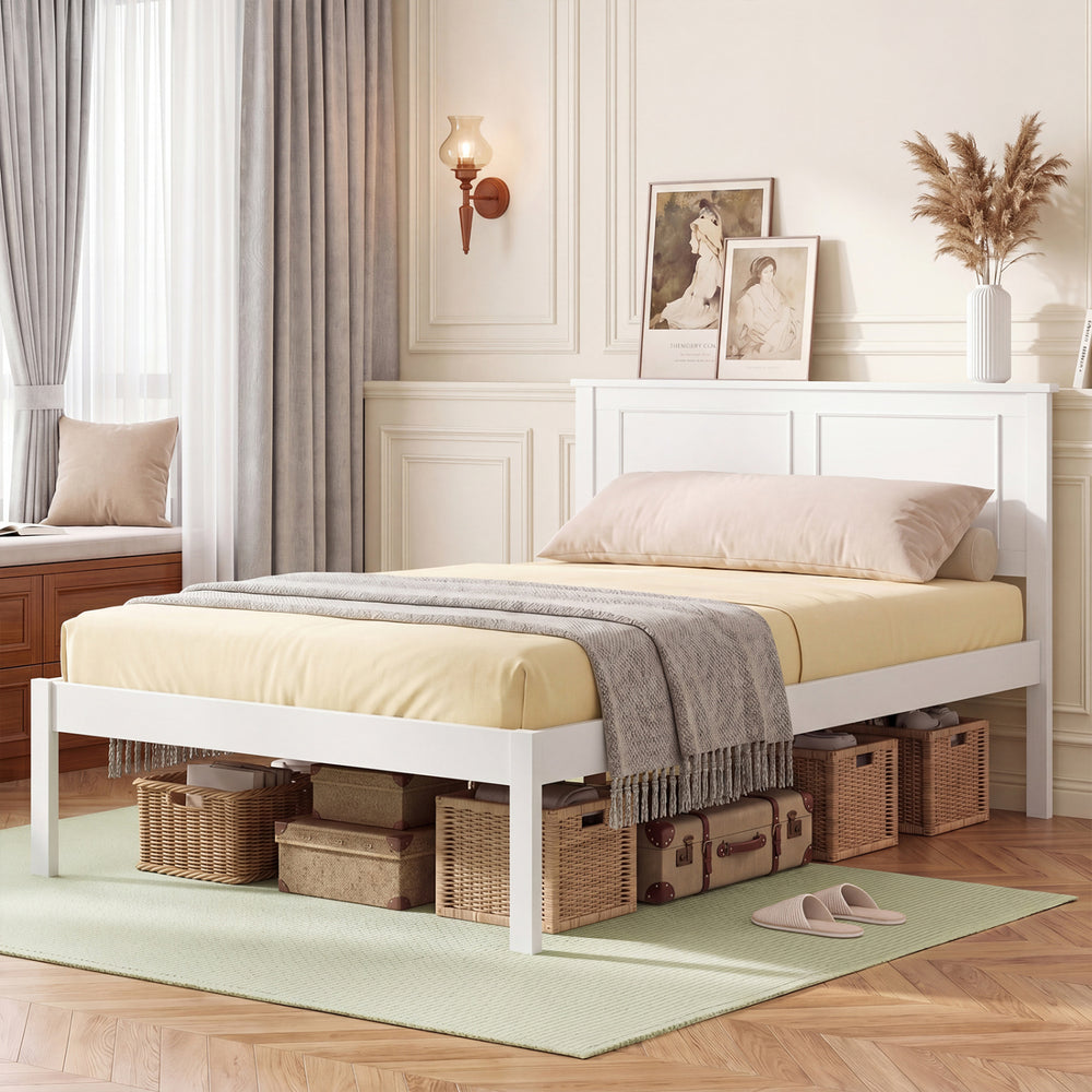 Twin size farmhouse wooden platform bed frame in white with headboard, styled with soft bedding and decorative elements.