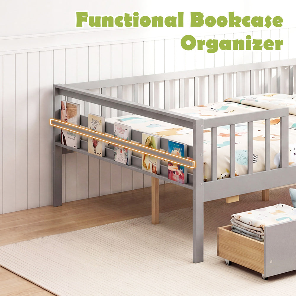 Full-size gray daybed with fence, two pull-out drawers, and side storage shelf for children's books and toys.