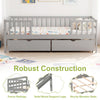 Full size gray daybed with fence, two pull-out storage drawers, and sturdy wooden slats for children's room.