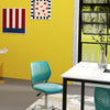 Swivel chair in turquoise with perforated back, part of a functional office furniture package for compact workspaces.