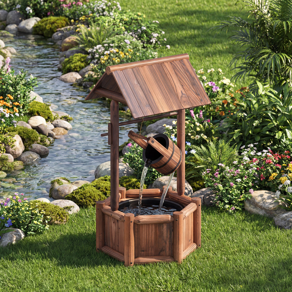 Wooden water fountain designed as a rustic wishing well, featuring a bucket and pump, ideal for garden or patio.