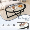 Oval tempered glass coffee table with black acacia wood legs and cross base, perfect for living room decor and.