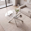 Round glass coffee table with a silver geometric frame, featuring a tempered glass top for modern living room decor.