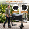 Large charcoal grill with wheels and folding tables, featuring a protective cover for outdoor cooking convenience.