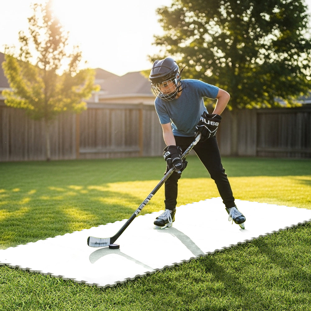 Young player practicing hockey on synthetic ice tiles made of premium UHMW-PE for realistic puck handling.