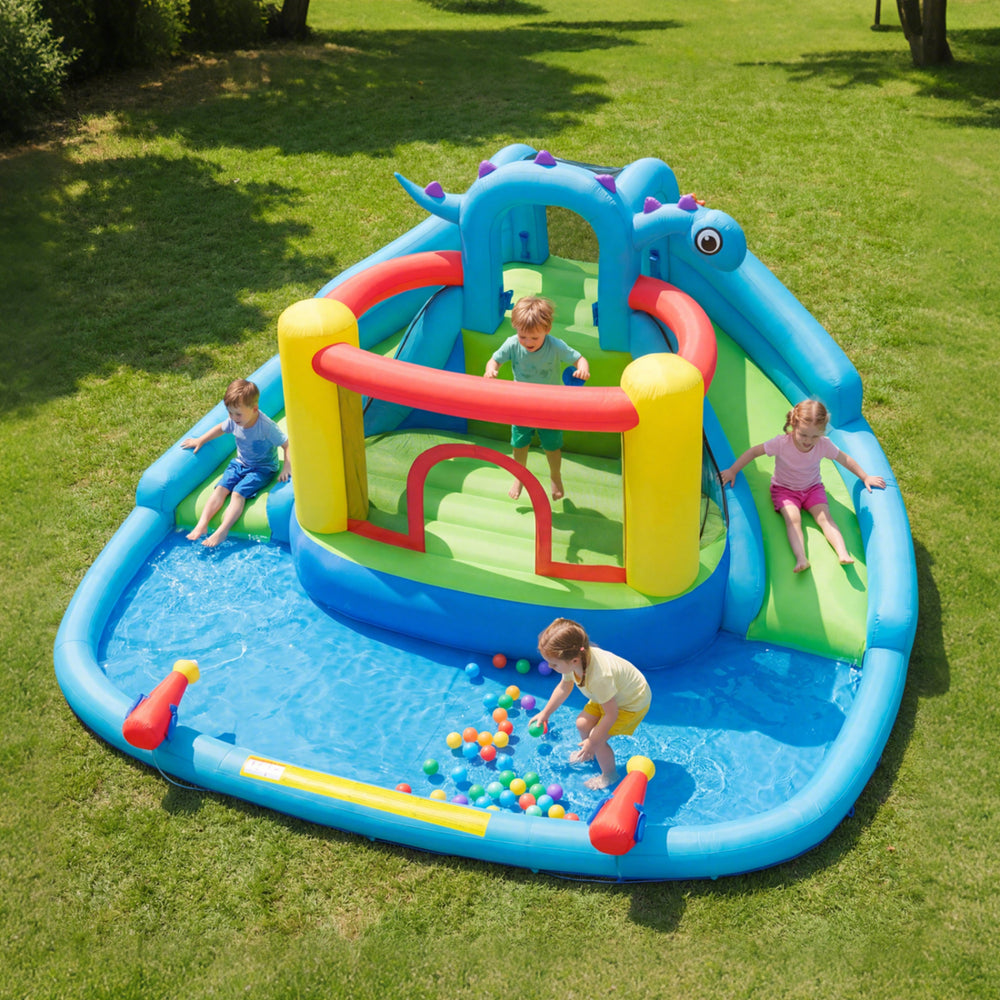 Kids enjoying the dinosaur-themed inflatable water slide park with splash pool, climbing wall, and colorful slides.
