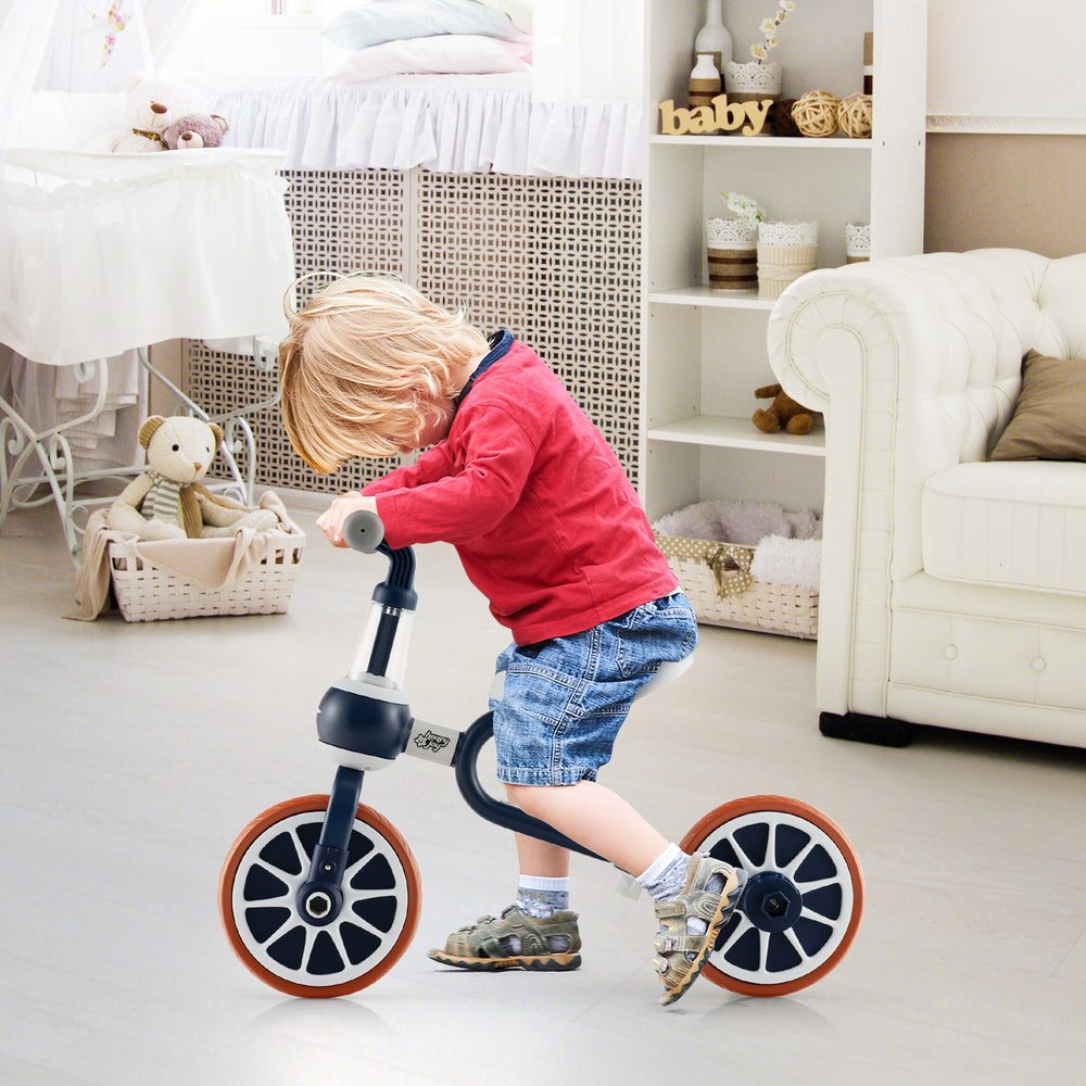 Kids riding the 4-in-1 navy trike bike indoors, featuring adjustable seat height and parent push handle.