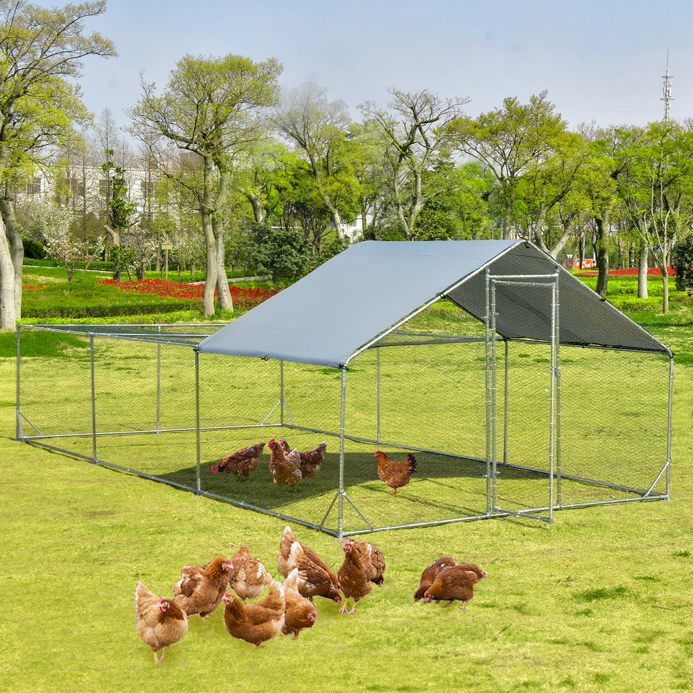 Large metal chicken coop with waterproof cover, featuring a sturdy design and ample space for pets in a grassy area.