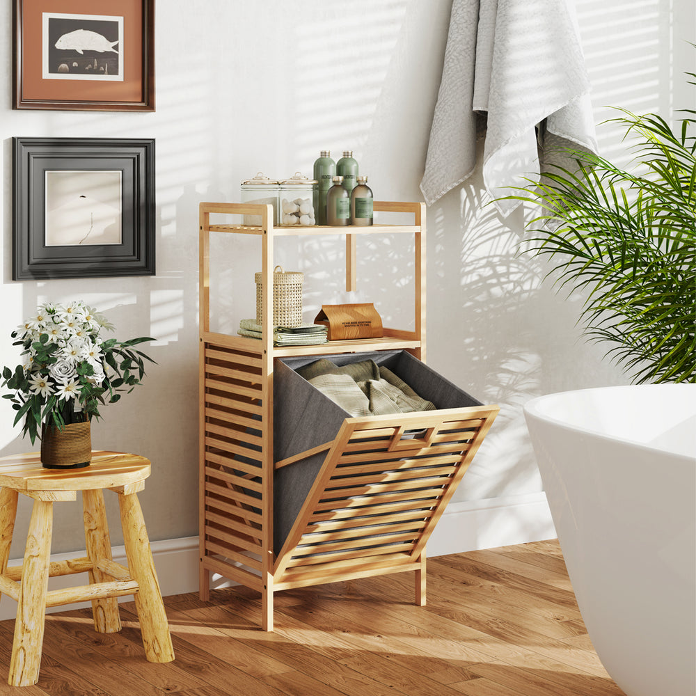 Bamboo tilt-out laundry hamper with removable basket, two shelves, and raised legs for bathroom or laundry room use.