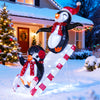 3D lighted Christmas decoration featuring two penguins on a slide, adorned with red hats and scarves, for festive.