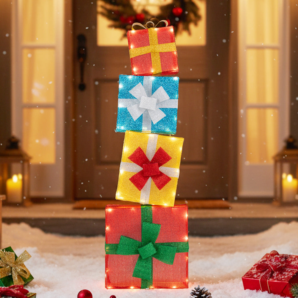 Stacked lighted gift boxes in vibrant colors with decorative bows, perfect for festive outdoor Christmas decoration.
