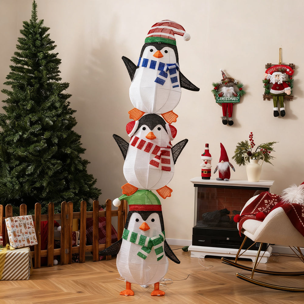 Stacked lighted penguin decoration with warm white lights, festive hats, and scarves for holiday cheer in any setting.
