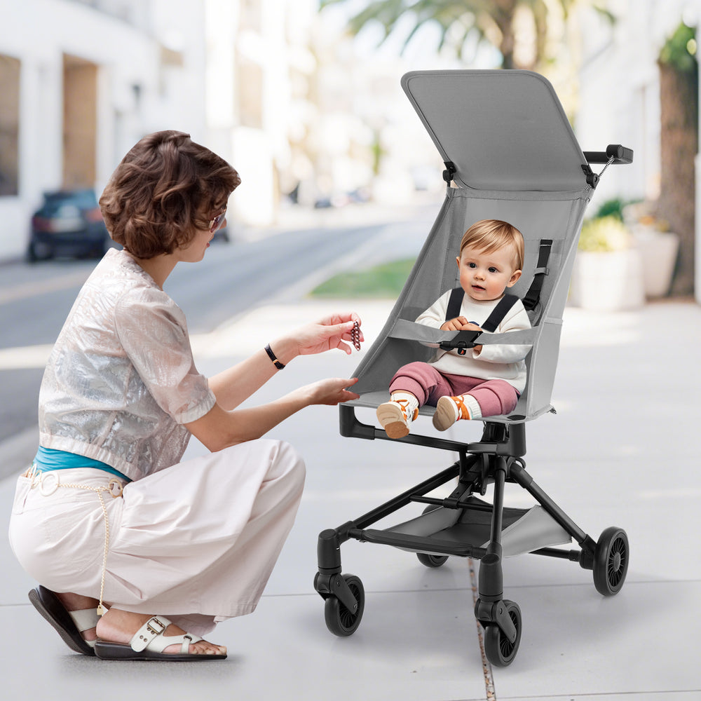 Lightweight gray baby stroller with adjustable canopy, compact design, and safety harness, perfect for travel.