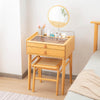 Bamboo makeup vanity table with rotating mirror, two drawers, and stool, ideal for organized cosmetics and beauty.