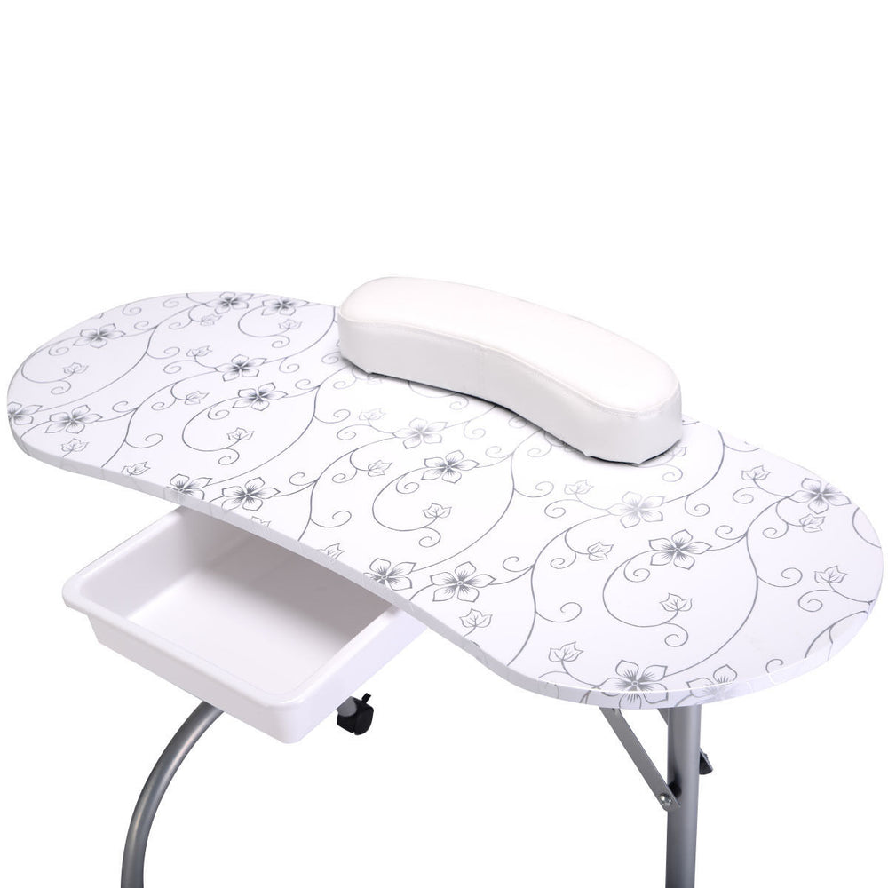 Portable white manicure nail table with floral design, comfy wrist cushion, and durable plastic drawer for accessories.