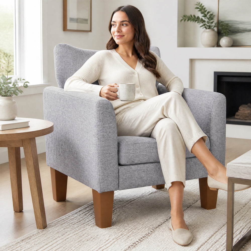 Modern gray accent chair with removable cushion and pillow, designed for comfort in living rooms and reading nooks.
