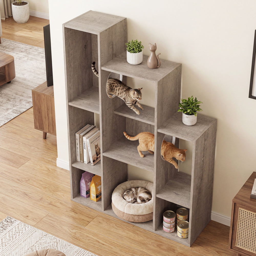 Modern cat bookshelf in gray oak featuring multi-level design, open shelves, and dual round hideaways for cats.