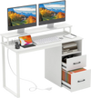 Modern computer desk in white with dual monitors, power outlets, file drawer, and organized workspace features.