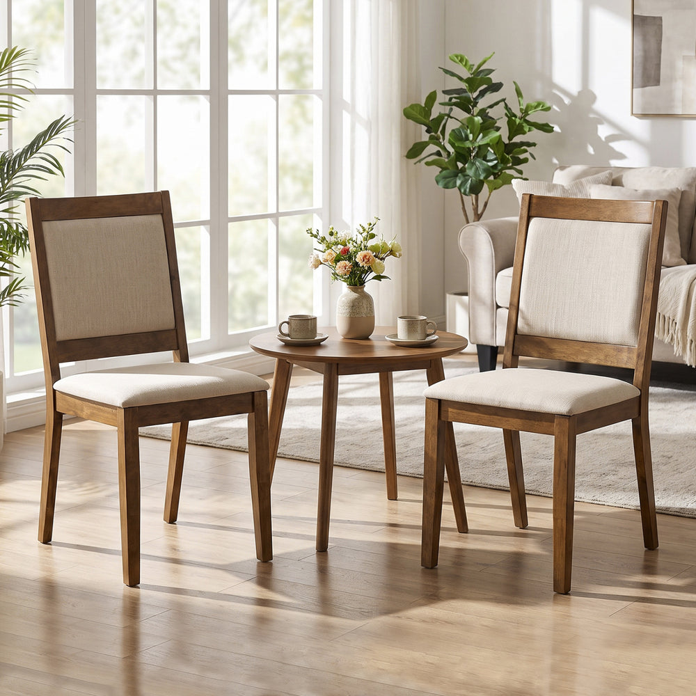Two modern dining chairs with padded beige cushions and a brown rubber wood frame, perfect for any living or dining area.