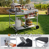 Movable grill table with spacious black tabletop, condiment caddies, and convenient bottle opener for backyard BBQs.