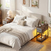 Narrow side table with LED lights, USB ports, and a spacious tabletop, perfect for small spaces in a cozy bedroom.