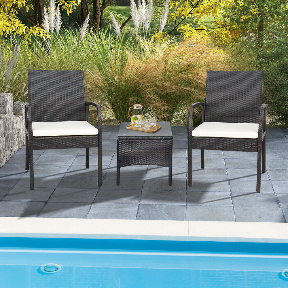 Two patio wicker dining armchairs with soft zippered cushions, set by the poolside for outdoor relaxation.