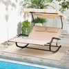 Outdoor 2-person rocking chaise lounge in beige with adjustable canopy, perfect for poolside relaxation.
