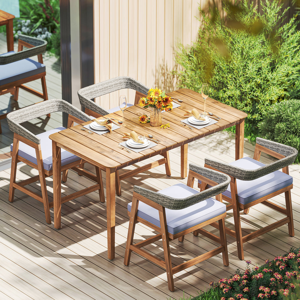 Outdoor acacia wood dining set featuring four wicker chairs with gray cushions, perfect for backyard relaxation.
