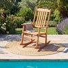 Acacia wood rocking chair with high back and armrests, perfect for outdoor relaxation by the poolside.
