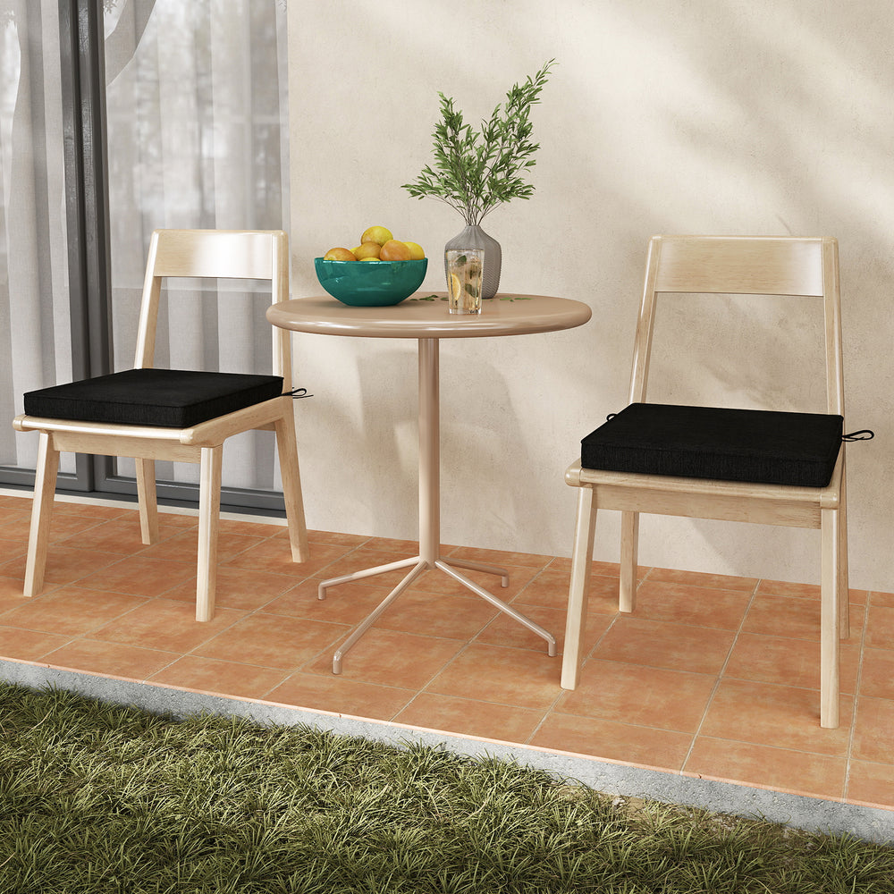 Black outdoor chair cushion set of 2, made of waterproof olefin fabric, shown on dining chairs for added comfort.
