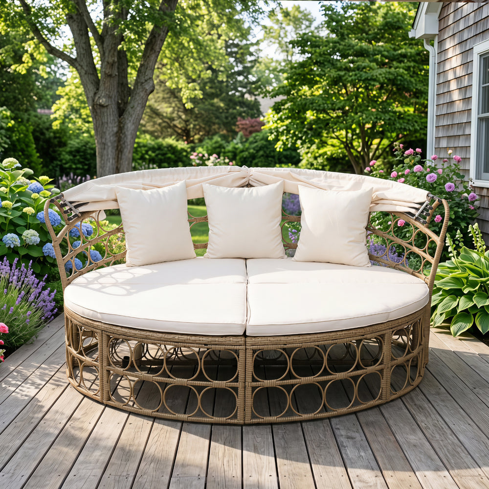 Outdoor patio daybed in yellow wicker rattan with retractable canopy and plush white cushions for garden relaxation.
