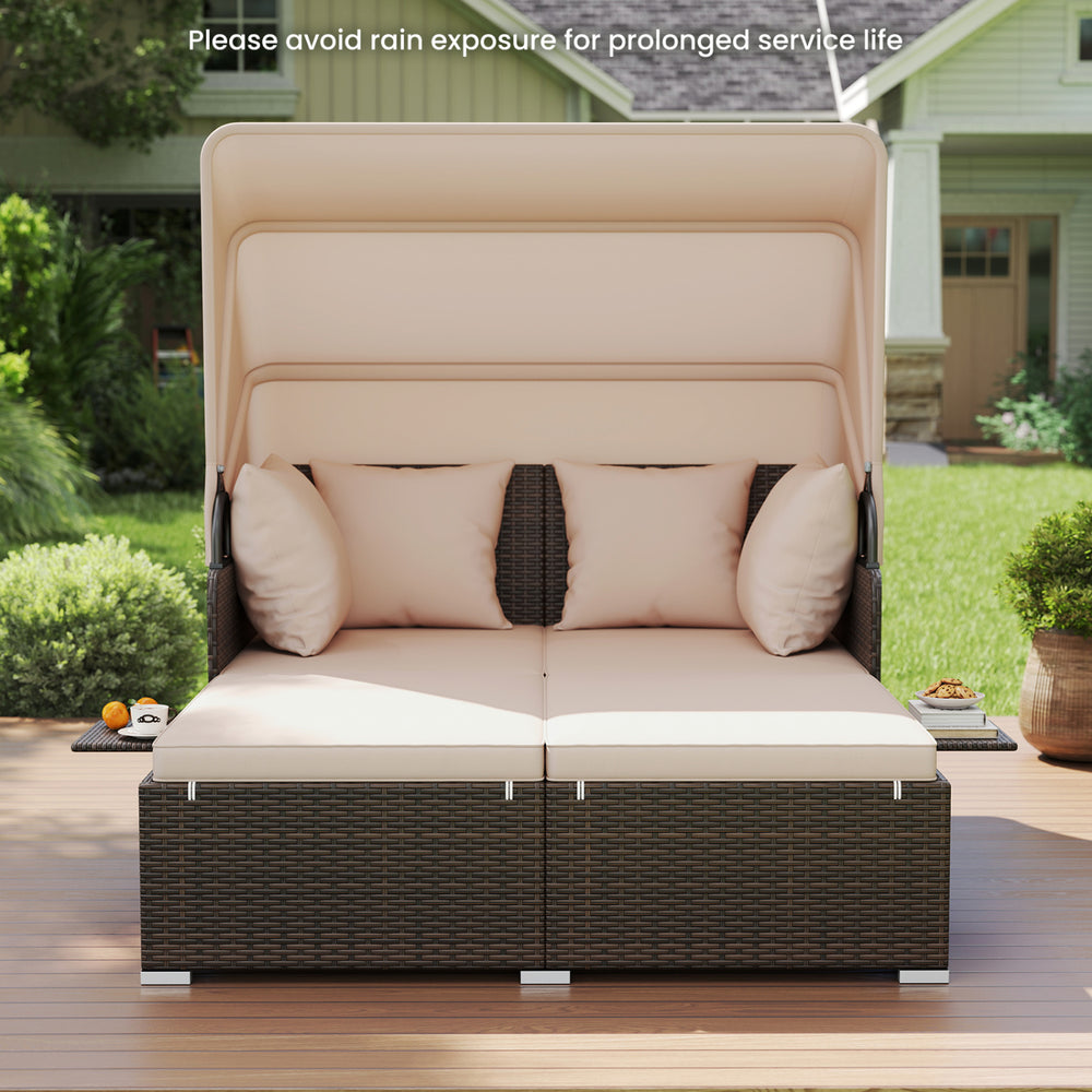 Outdoor patio rattan daybed with beige cushions and retractable canopy, perfect for backyard relaxation.