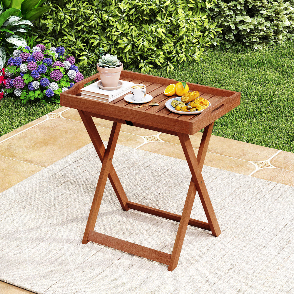Foldable outdoor patio tray table made of solid wood with removable top, perfect for serving snacks in the garden.