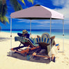 Outdoor pop-up canopy tent in pink, 6.6' x 6.6', adjustable height, providing shade for beach relaxation.