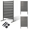 Freestanding outdoor privacy screen fence in gray features slatted panels for airflow and includes metal ground stakes for stability.